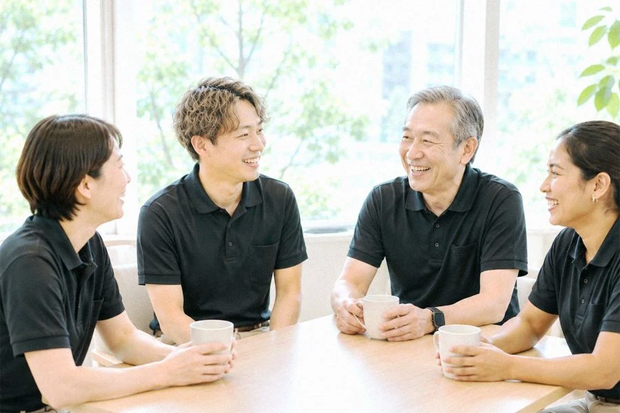 多様な4人の社員が屋外で語り合う様子