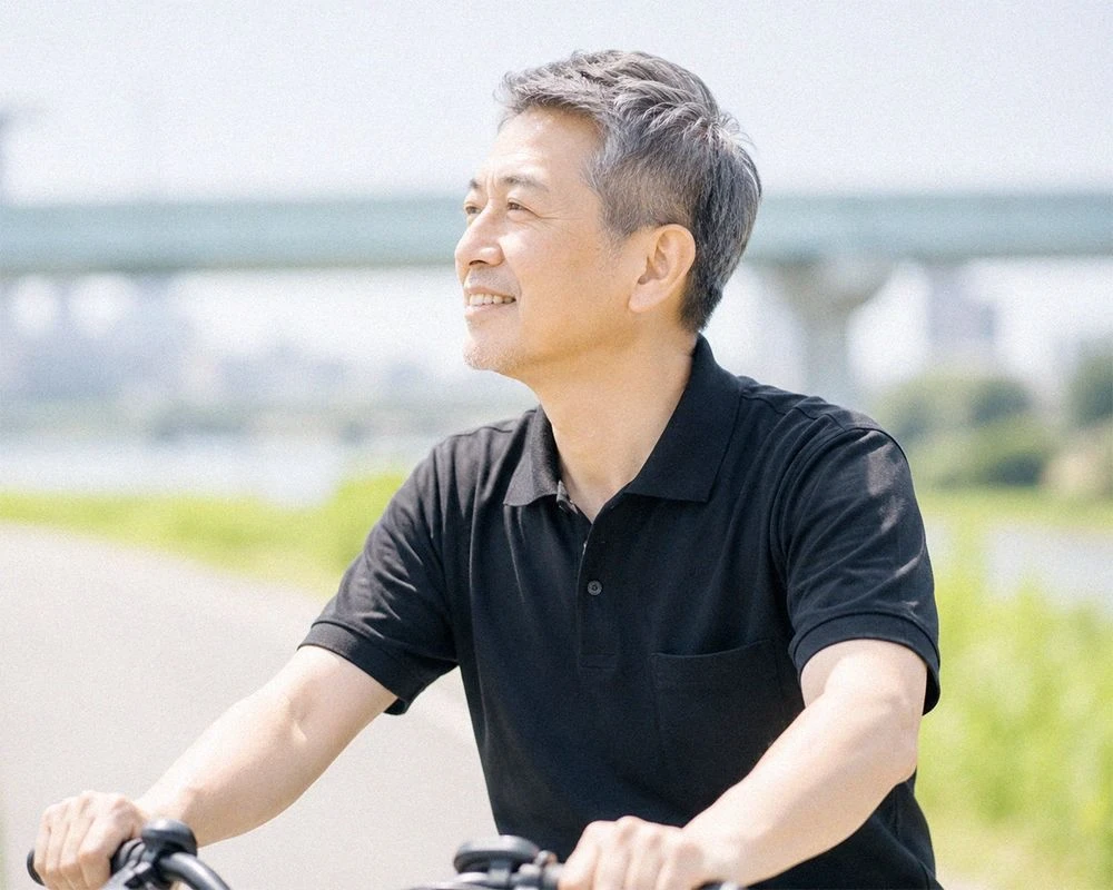 自転車で街を走る、笑顔のミドル世代の男性社員