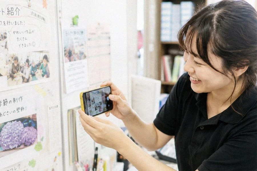 掲示物をスマートフォンで撮影するスタッフ